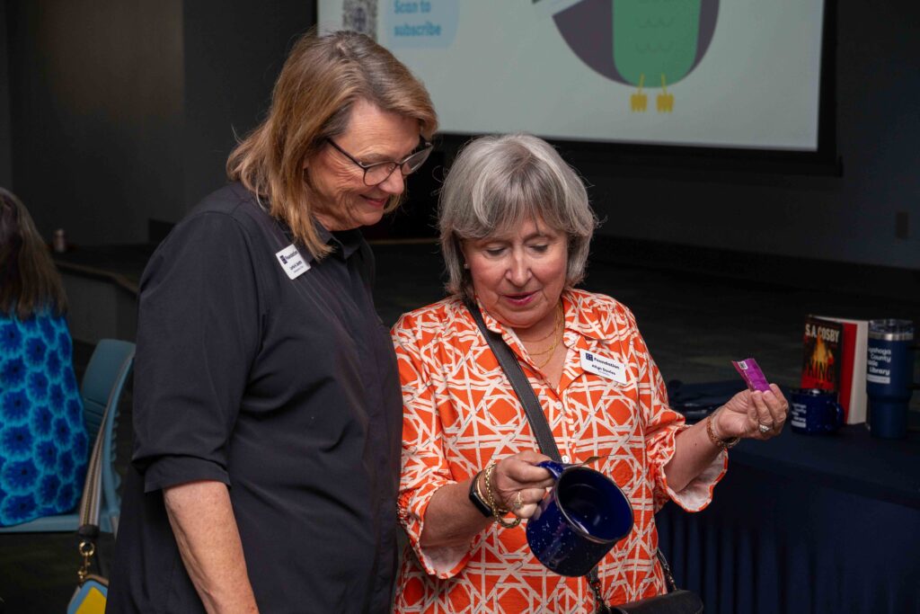 Two guests look at a CCPL mug.