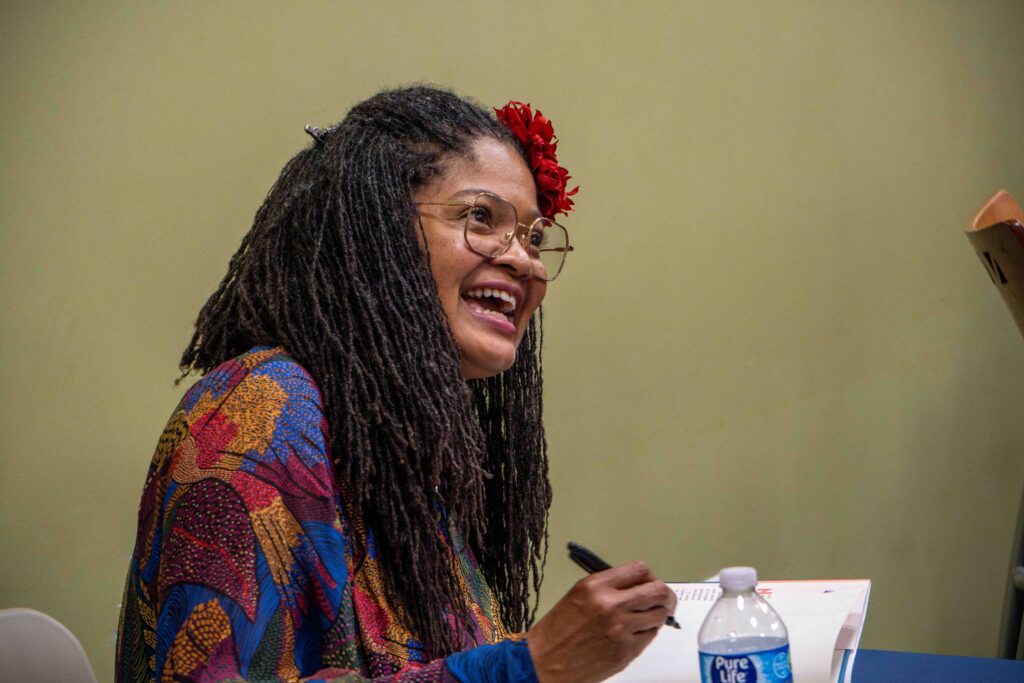 Author Dolan Perkin-Valdez signs a copy of her book.